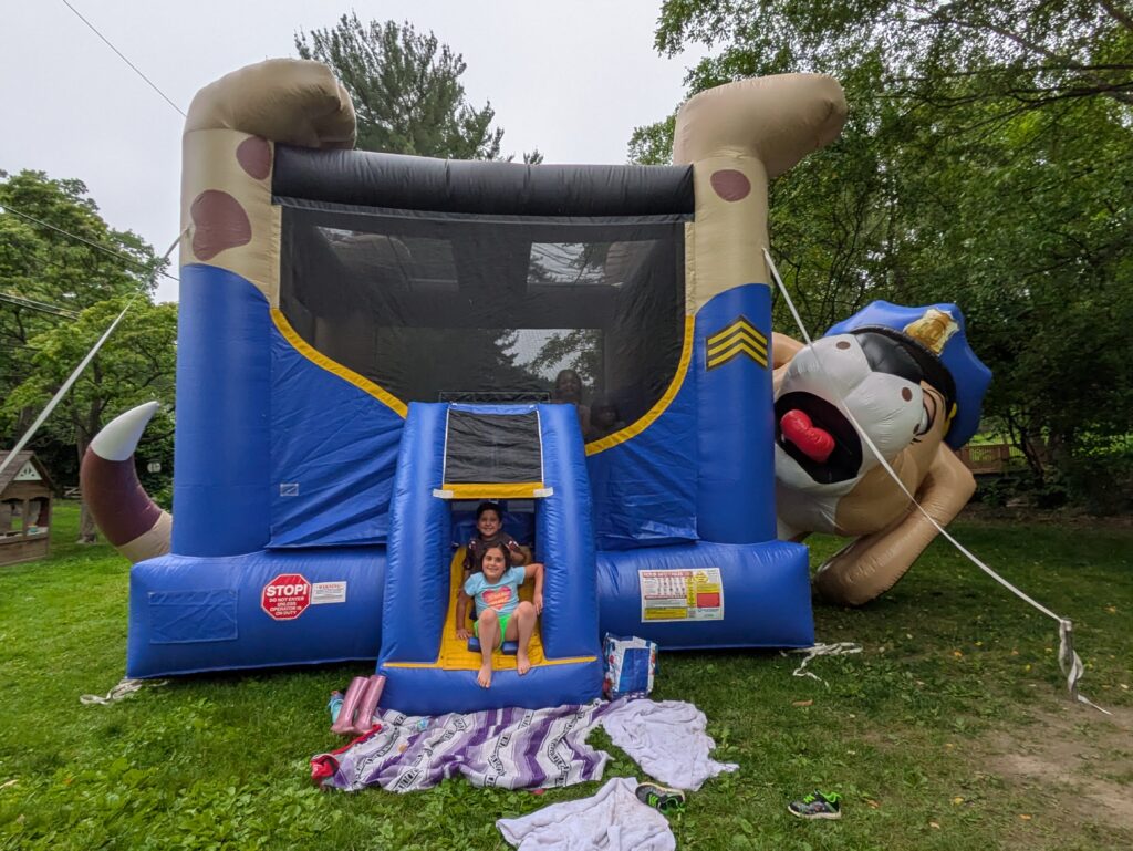 two children pose in front of a bouncy house in Shortridge Park