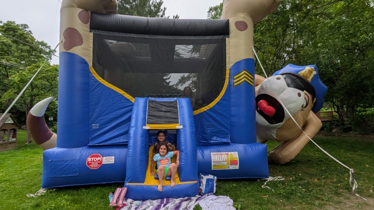two children pose in front of a bouncy house in Shortridge Park